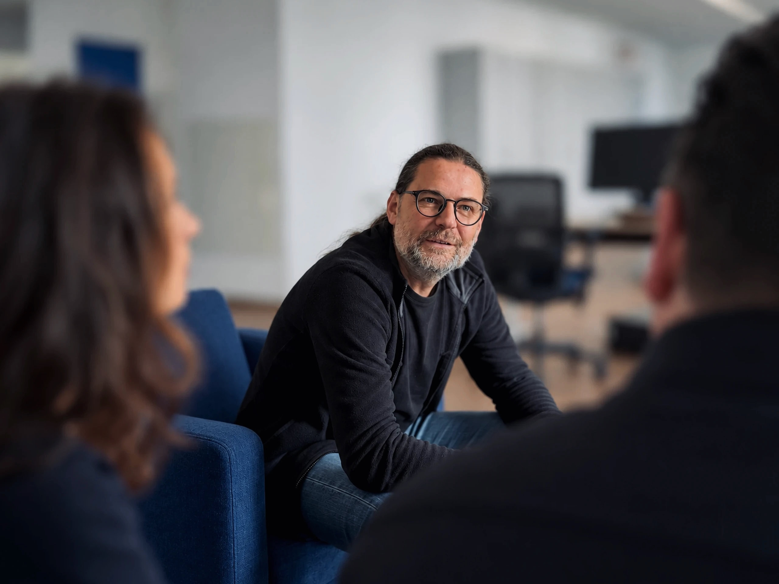 Warnow Design team member in conversation with colleagues in the lounge area