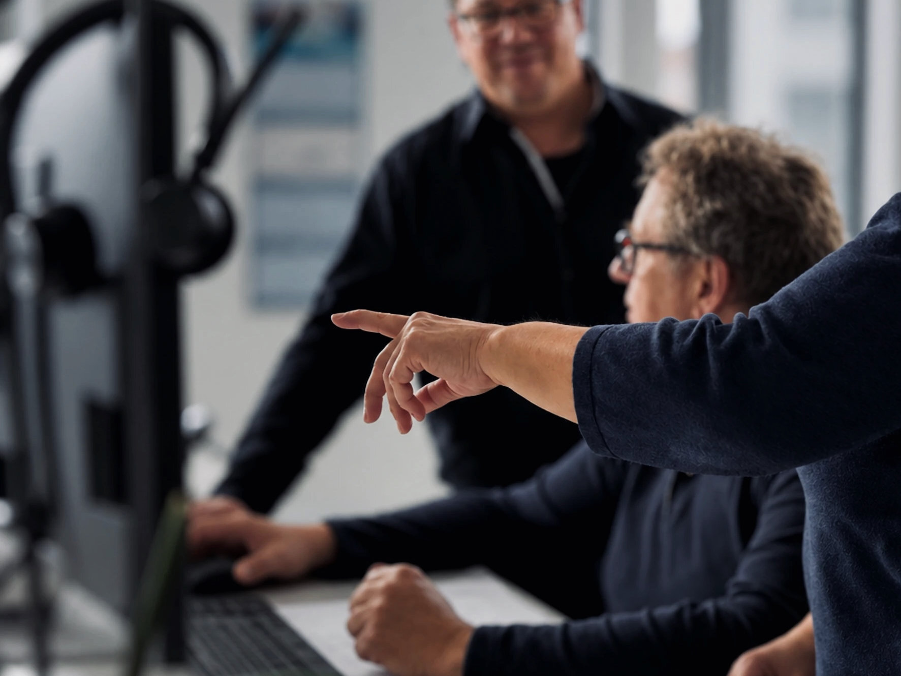 Warnow Design team member pointing out something on a monitor to colleagues