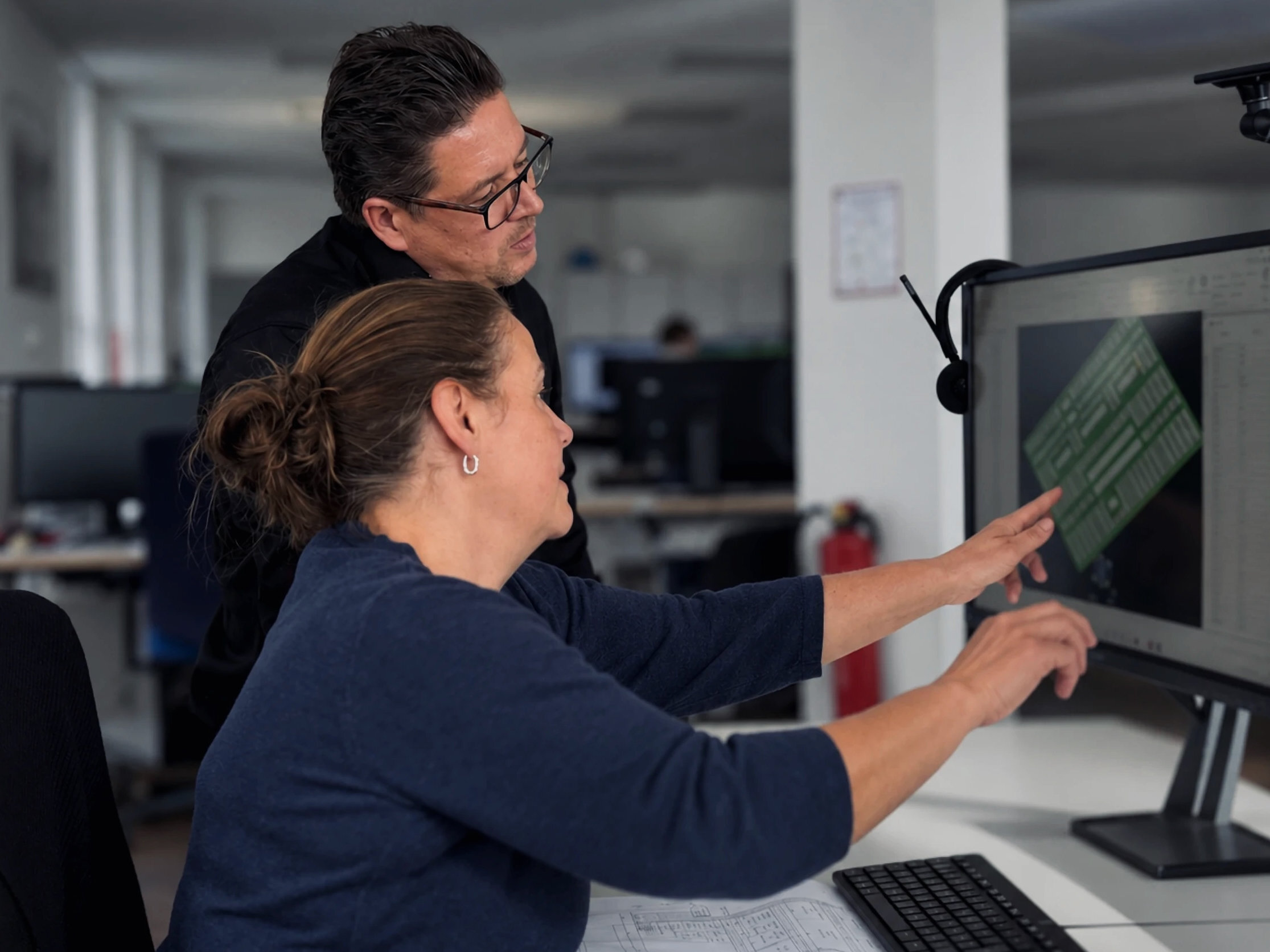 Engineer pointing at a CAD design on screen