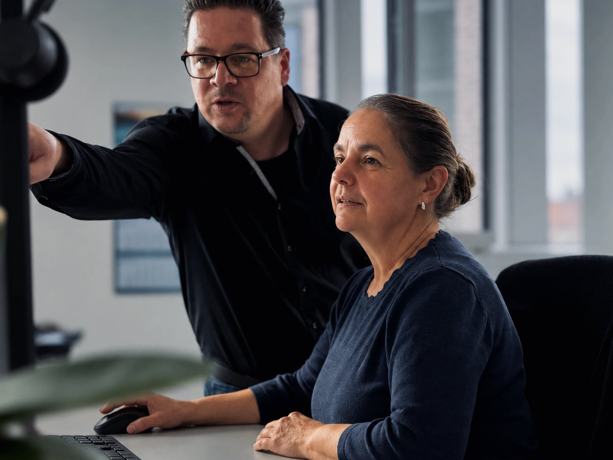 Warnow Design engineer pointing something out on a colleague's monitor