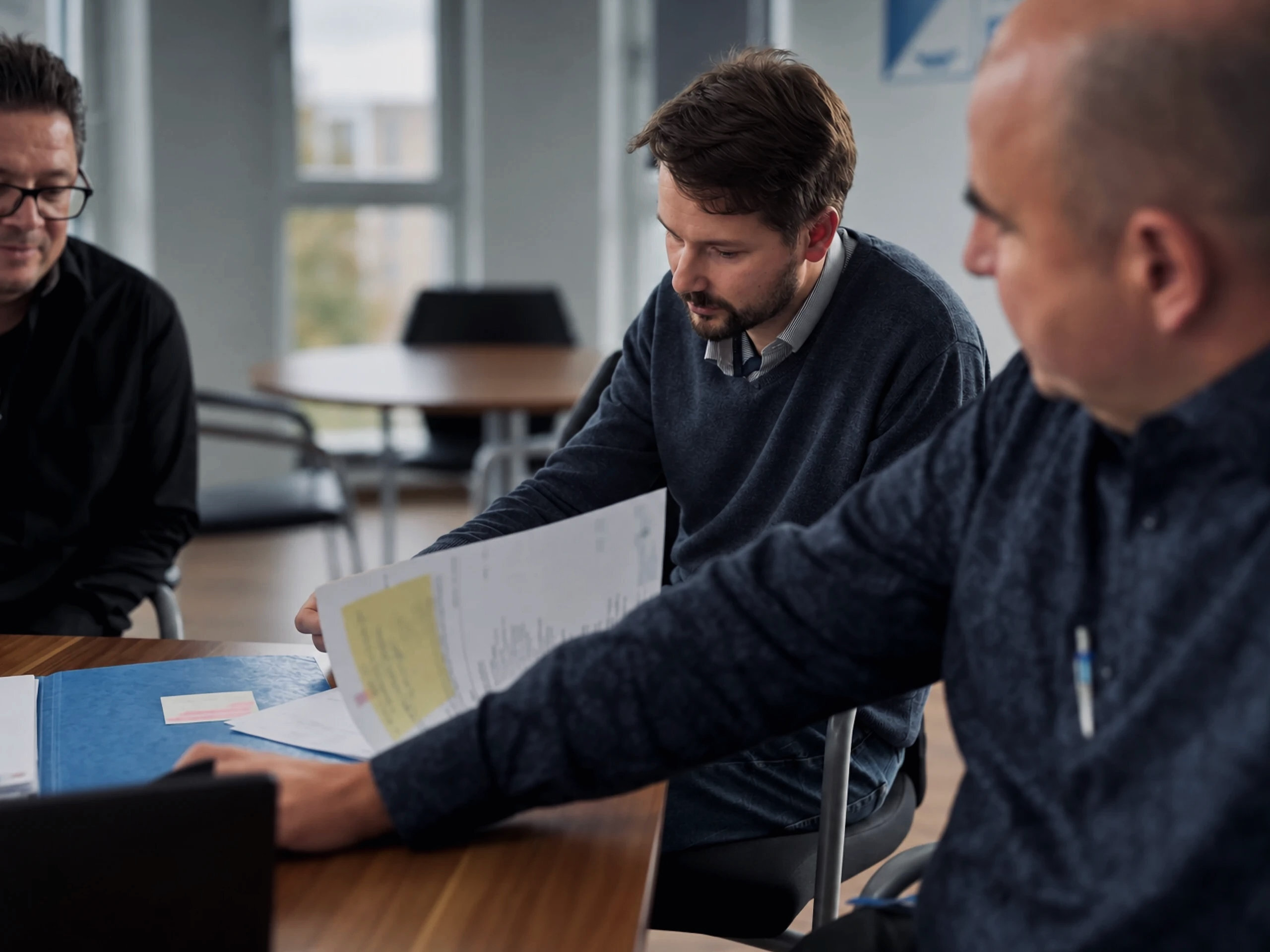 Ingenieure von Warnow Design gehen am Besprechungstisch gemeinsam Unterlagen durch